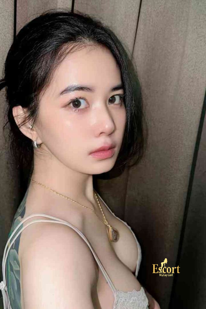 Escort Malay Girl Adeline, a 22-year-old C cup Thailand escort in KL, poses for a photo wearing a white lace bra and gold necklace KL Escort Girl Service