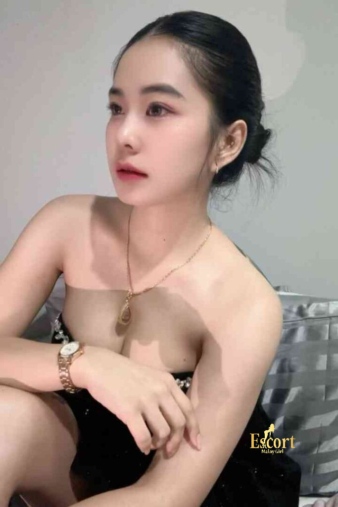 Escort Malay Girl Adeline, a 22yo C cup Thailand escort, posing for a photo in a black dress KL Escort Girl Service