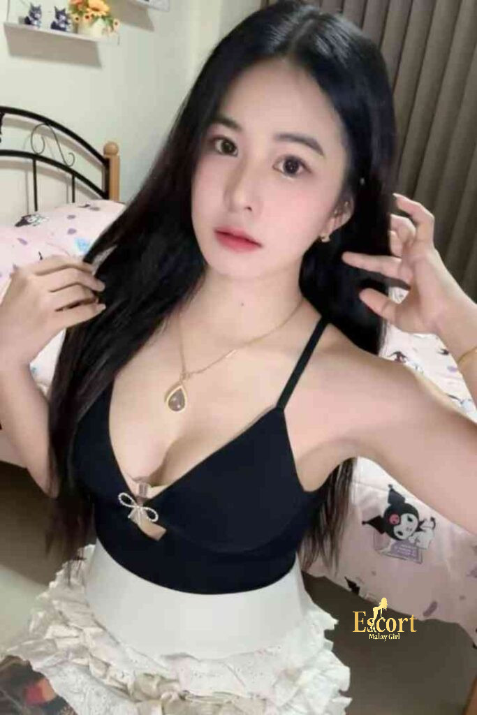 Escort Malay Girl Adeline, a 22yo C Cup Thailand Escort in KL, poses indoors wearing a black and white outfit KL Escort Girl Service