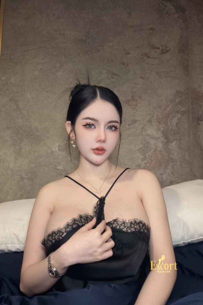 Escort Malay Girl Grace Thailand Escort in black lace top holding a watch sitting on bed KL Escort Girl Service