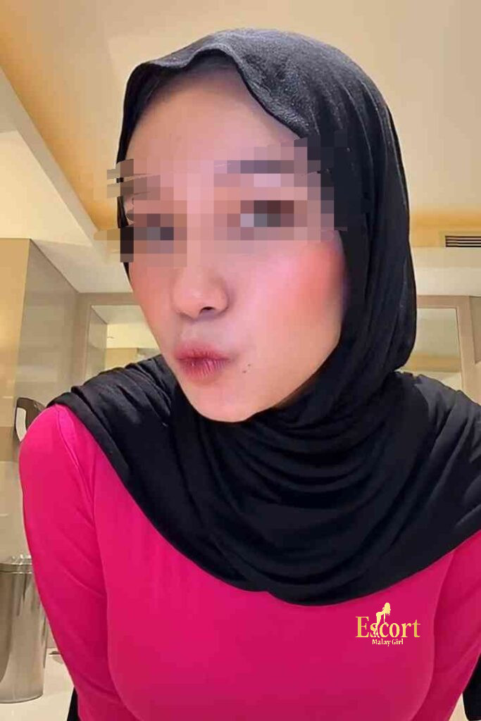 Escort Malay Girl Kirana, a 23yo Malay escort in Kuala Lumpur, wears a pink shirt and black hijab KL Escort Girl Service