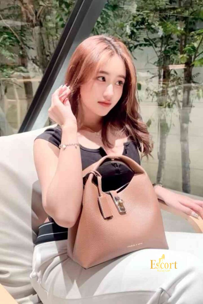 Escort Malay Girl Laila Malay Escort, sitting with a brown leather handbag on her lap KL Escort Girl Service