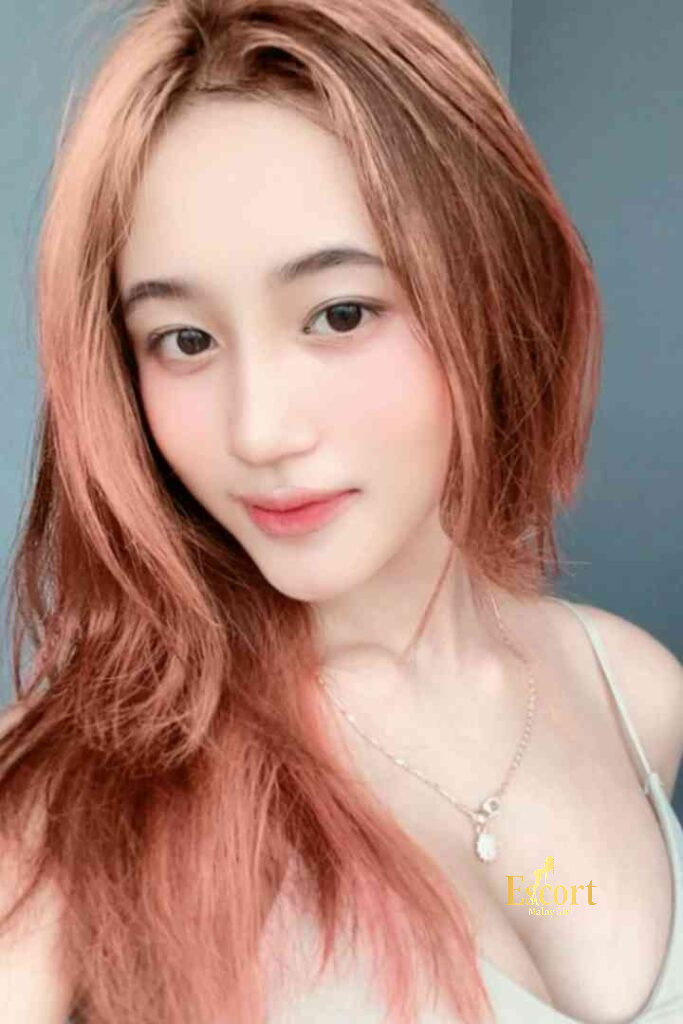 Escort Malay Girl Laila Malay Escort with pink hair smiling, wearing silver necklace KL Escort Girl Service