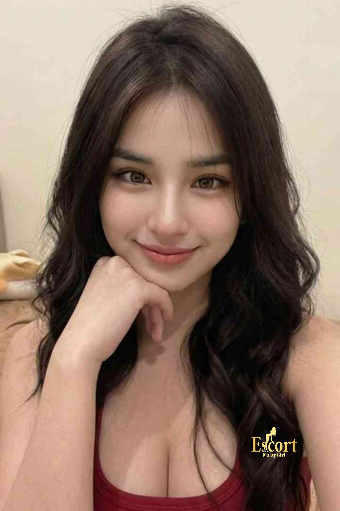 Escort Malay Girl Ummi, 22yo C Cup Malay Escort in KL, smiling with hand on chin KL Escort Girl Service