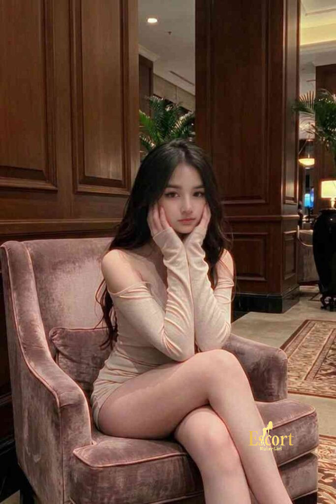 Escort Malay Girl Ummi, a 22yo C Cup Malay Escort in KL, sitting on a purple chair, looking elegant KL Escort Girl Service