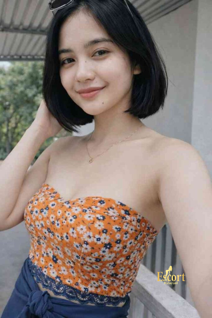Escort Malay Girl Young Malay escort Vira, 24, with D cup breasts, wearing an orange floral top KL Escort Girl Service