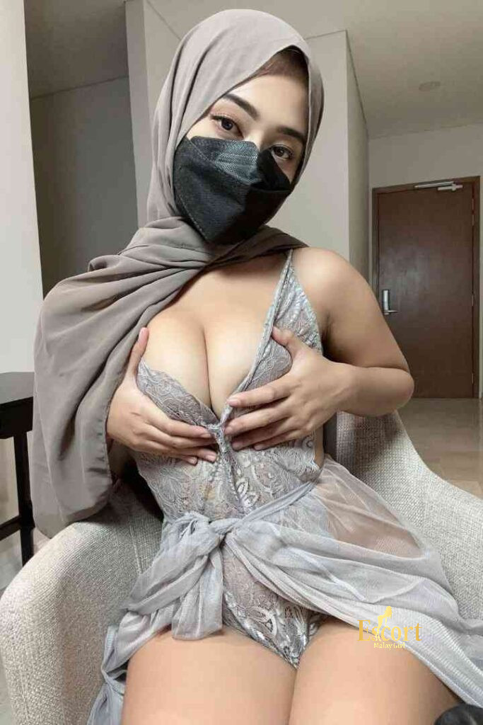 Escort Malay Girl Sarah, a 23-year-old Malay escort and call girl in Kuala Lumpur, wearing a hijab and mask, posing in a grey negligee. KL Escort Girl Service