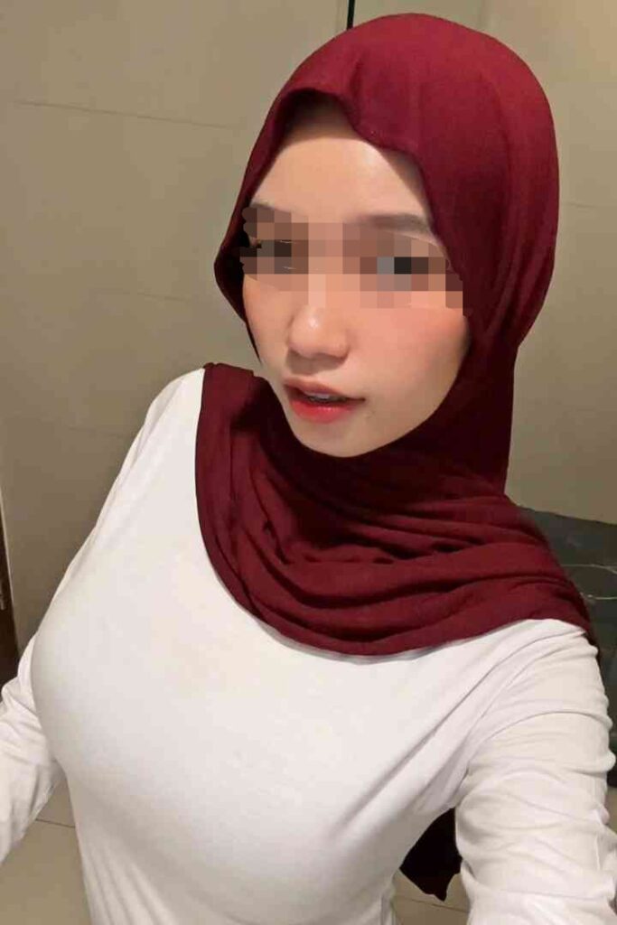 Escort Malay Girl Close-up of a woman in a red hijab and white long-sleeve shirt KL Escort Girl Service