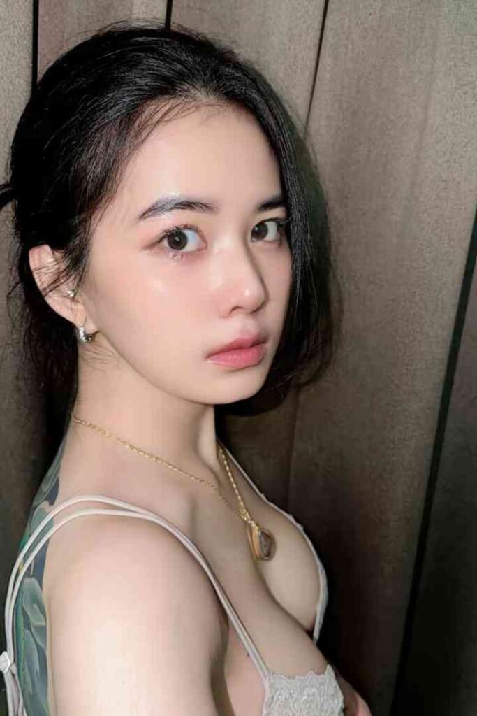Escort Malay Girl Young woman with dark hair, light skin, and a delicate necklace. KL Escort Girl Service